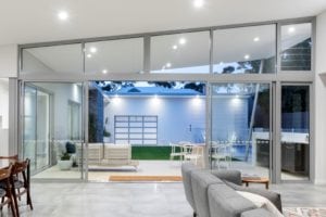 Light grey sliding doors opening up into the lounge and pool area from the living room of a Perth home.